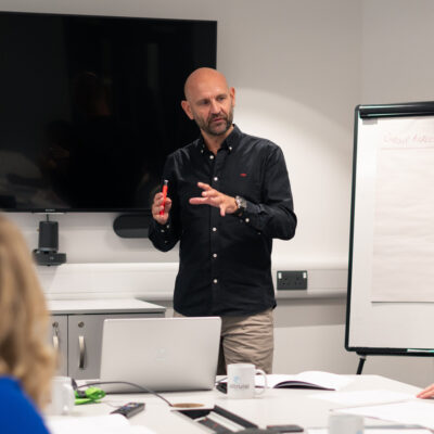 Mental Health expert leads a Wellbeing session alongside a large flipchart.