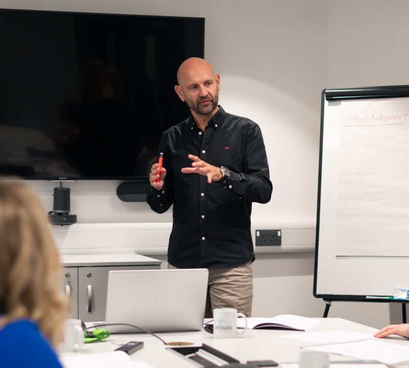 Mental Health expert leads a Wellbeing session alongside a large flipchart.