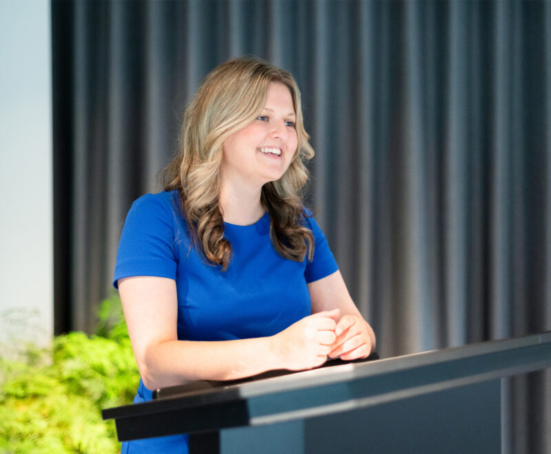 Wellbeing Expert stands behind a podium delivering a Mental Health talk.