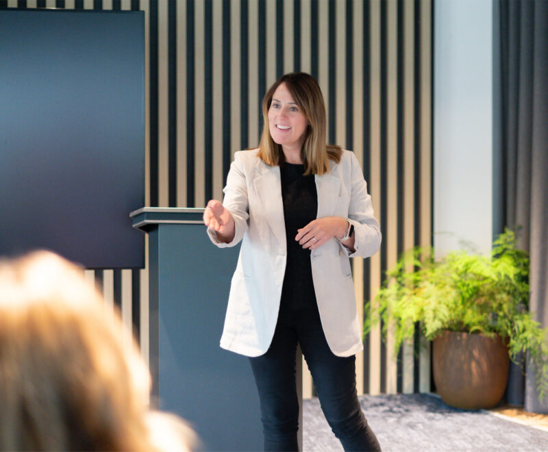 Wellbeing Expert leads a Mental Health talk in front of a lectern.