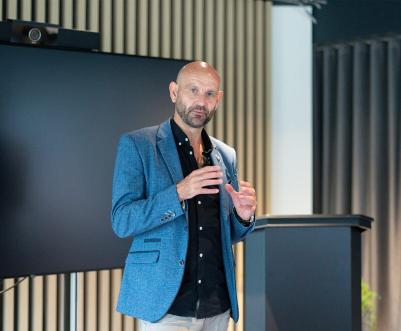 Wellbeing Expert leads a Mental Health talk in front of a screen and podium.