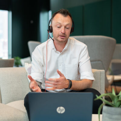 Wellbeing Instructor leads an Online Mental Health course using a laptop and headset.