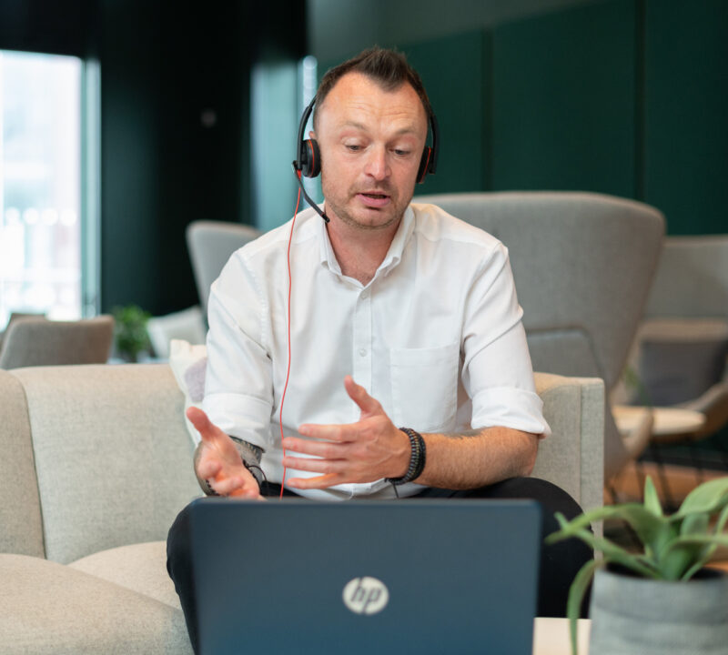 Wellbeing Instructor leads an Online Mental Health course using a laptop and headset.